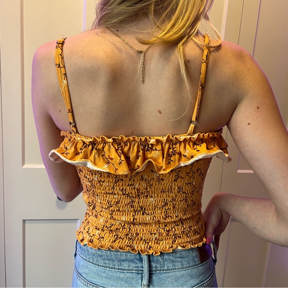 Shirred, orange, cropped tube top with frilled hem and brown floral details